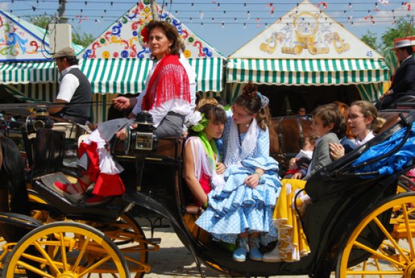 A family in traditional dress rides in a carriage in Sevilla.