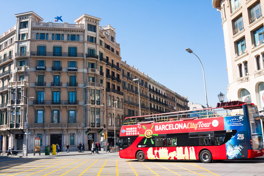 A Hop On Hop Off bus travels through Barcelona's Catalonia Square.