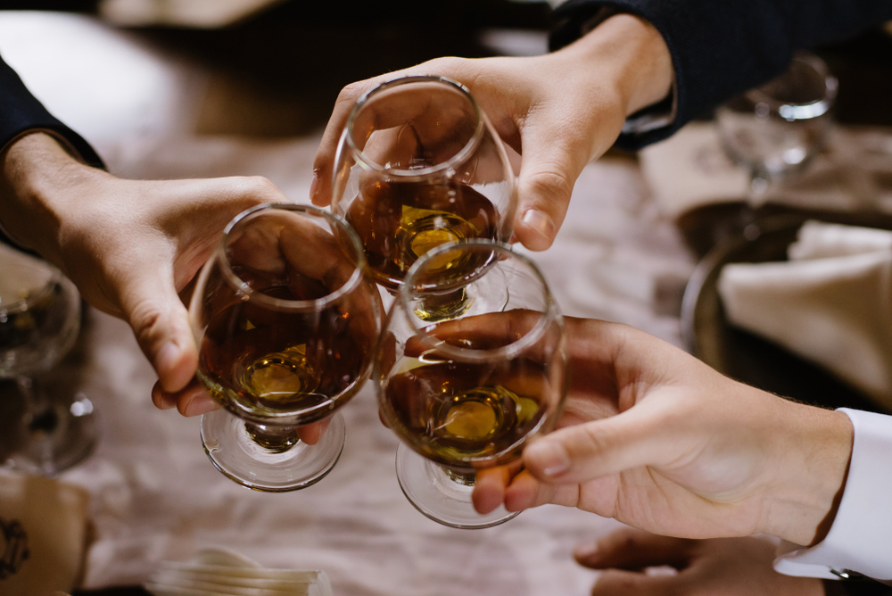 Friends Toast With Glasses of Cognac Served Neat