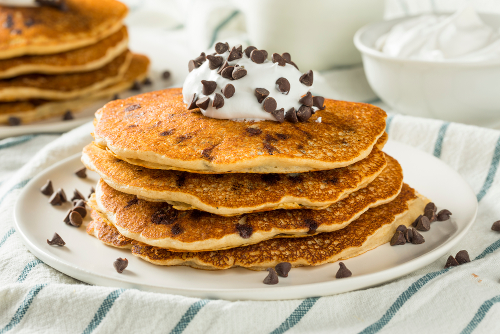 Chocolate Chip Pancakes topped with whipped cream.